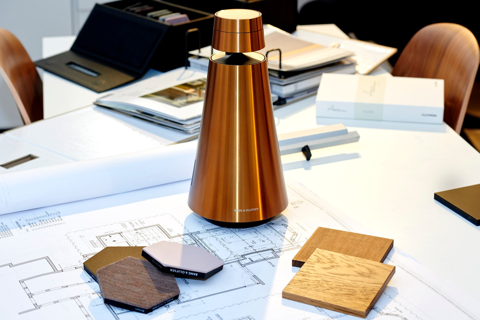 SoWa showroom: a bronze speaker with fabric and wood samples on architectural plans